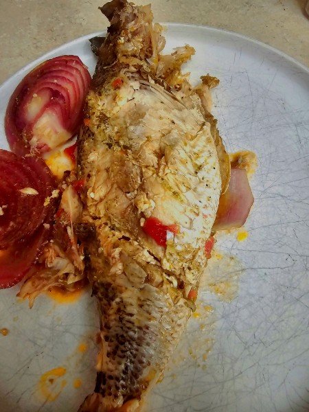 Whole roasted fish with red onion and peppers
