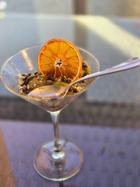Chilled dessert in a martini glass with a dried orange slice